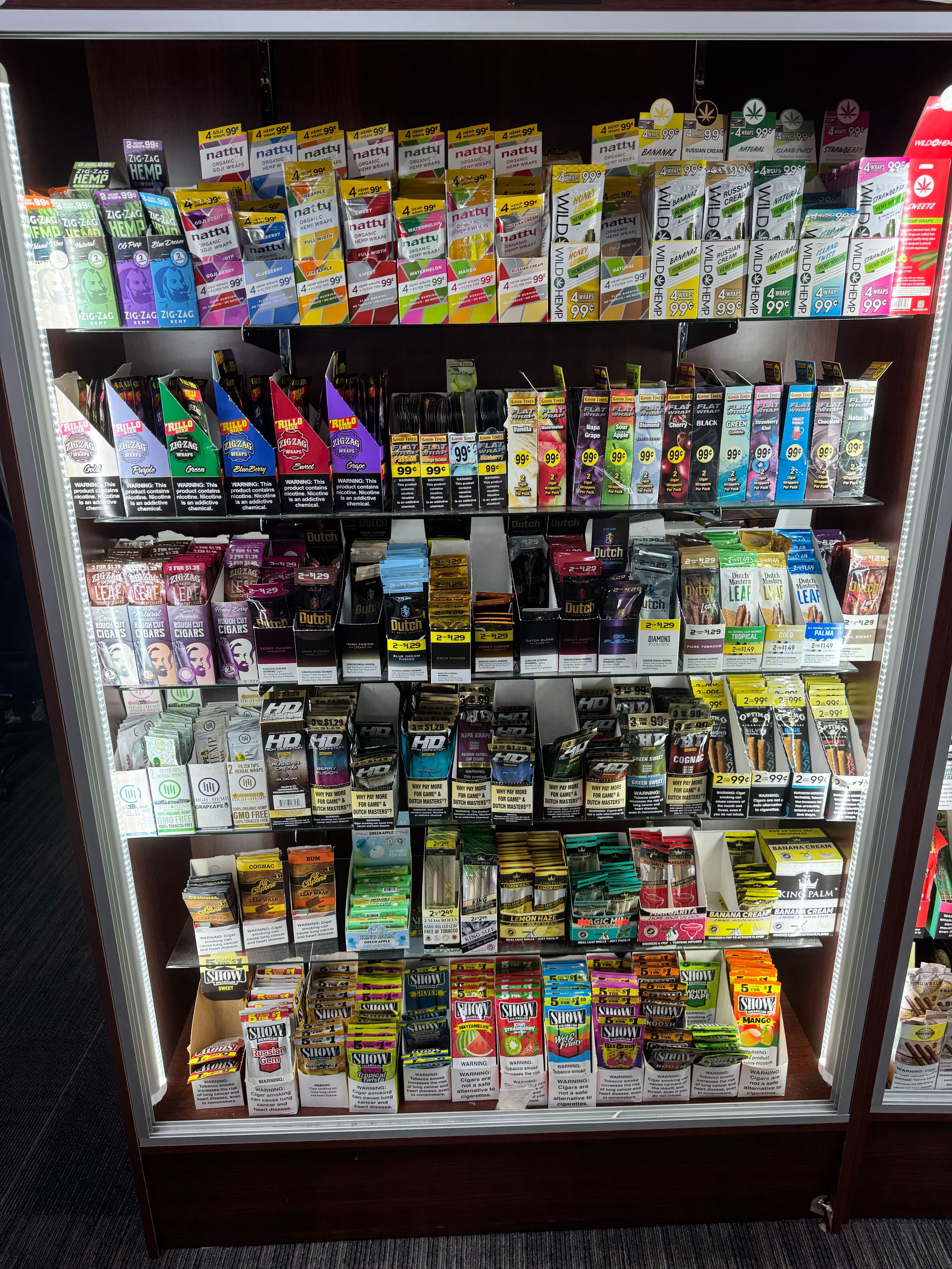 Convenience store display case filled with colorful tobacco and smoking products
