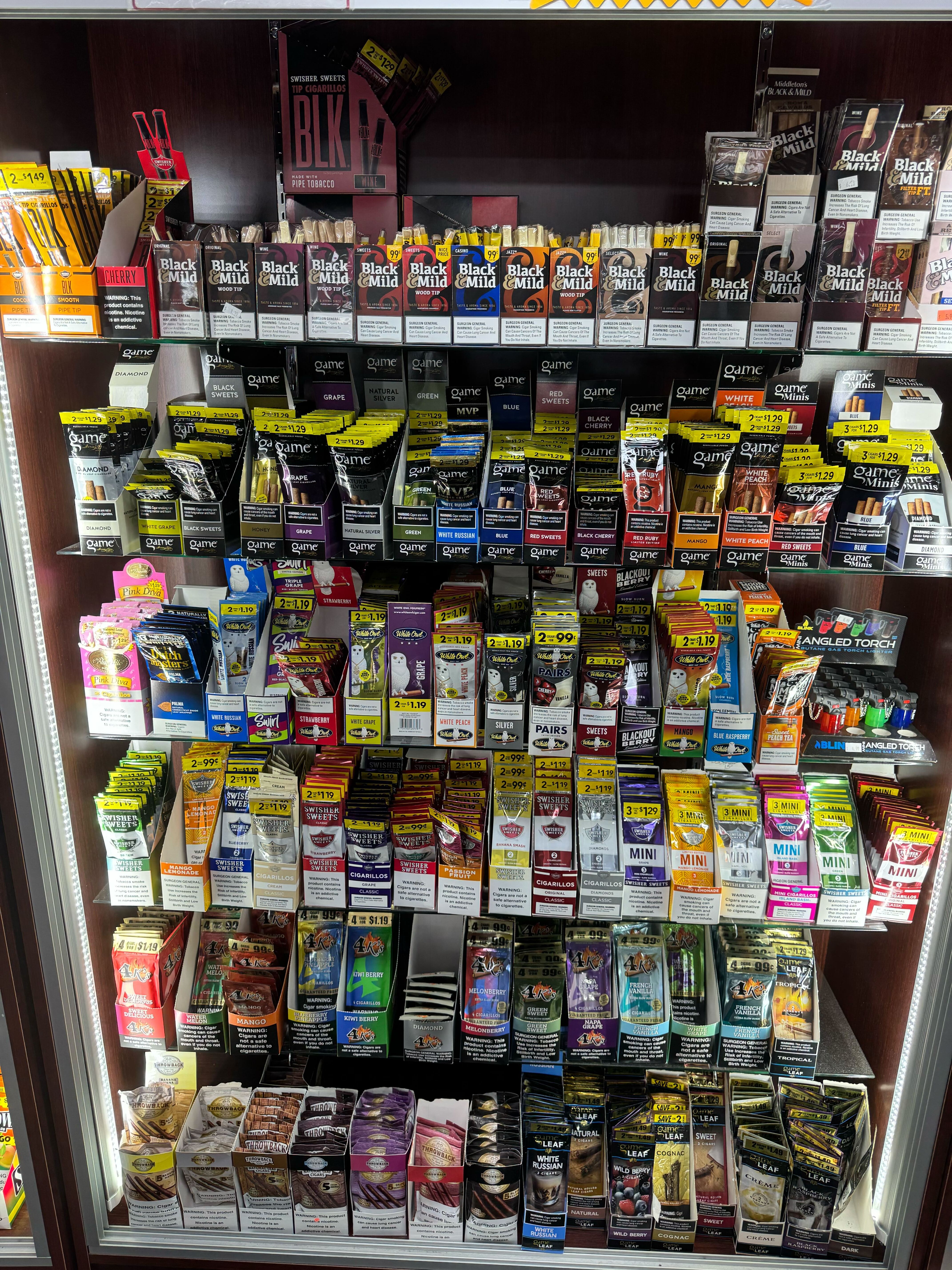 Convenience store shelf filled with various tobacco and smoking products
