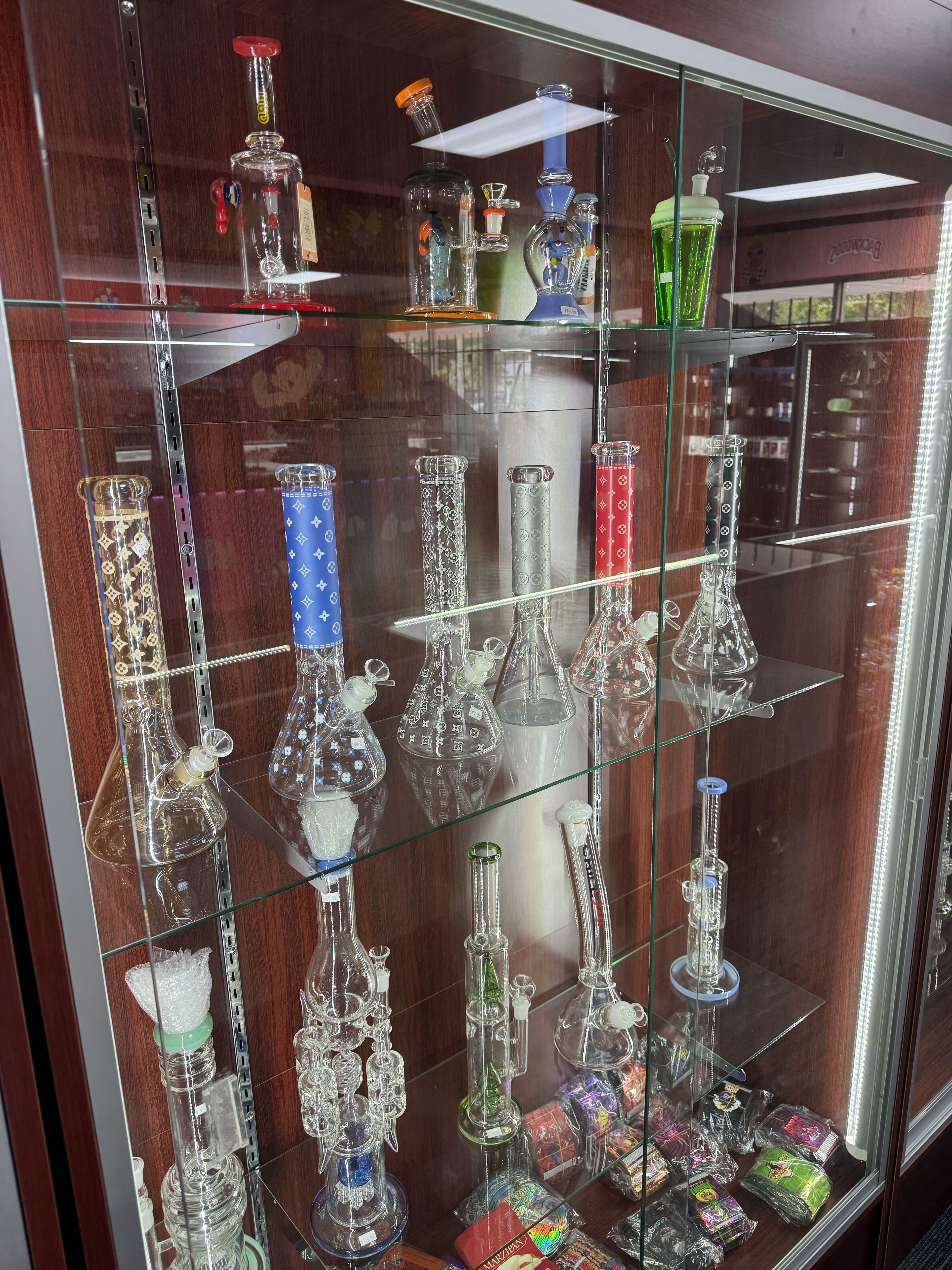 Glass display case filled with colorful smoking devices and accessories